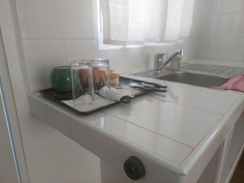 a kitchen counter with two glass jars and a sink at Posada Santa Elena in Santa María Atlihuetzián