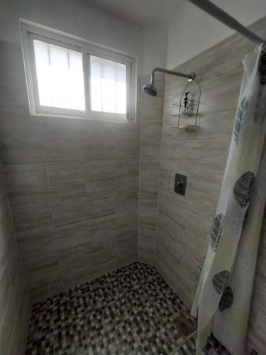 a bathroom with a shower with a window at Posada Santa Elena in Santa María Atlihuetzián