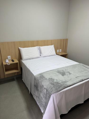 een slaapkamer met een groot bed en twee nachtkastjes bij HS Hotel in Sao Paulo