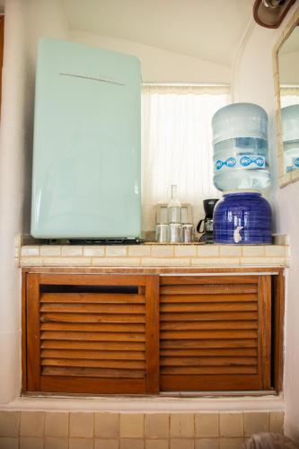 a kitchen cabinet with a microwave on top of it at Sayulita Central Hotel in Sayulita