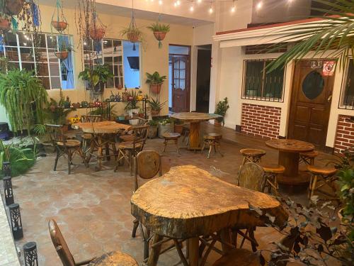 un restaurante con mesas de madera, sillas y plantas en Hostal San José, en Somoto