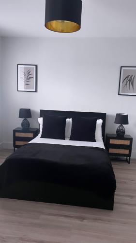 a bedroom with a black bed and two lamps at 3 Bedroom House Near City Centre Glasgow Sleeps 7 in Glasgow