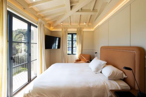 une chambre avec un lit et une grande fenêtre dans l'établissement Magnifique villa RIVA avec piscine aux salins, à Saint-Tropez