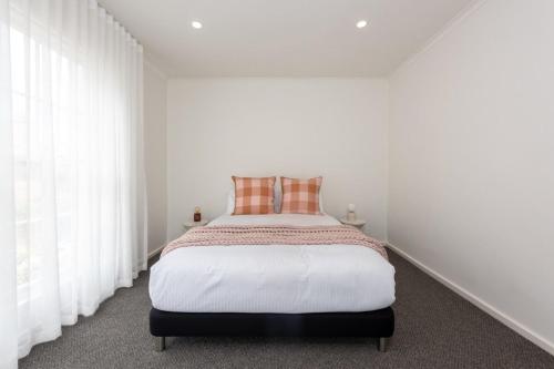 a white bedroom with a bed with white curtains at Elegant 2-bedroom House in Prahran w Parking! in Melbourne