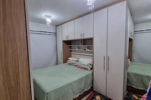 Dormitorio pequeño con 2 camas y armarios blancos en HOME em Condomínio Resort Pontal Oceânico Recreio, en Río de Janeiro