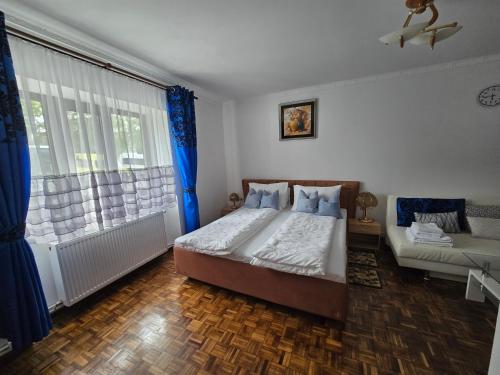 a bedroom with a bed and a couch and a window at ELDI House in Făgăraş