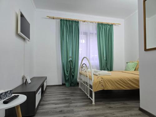 a bedroom with a bed and green curtains at ELDI House in Făgăraş