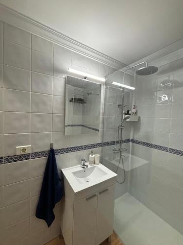 a white bathroom with a sink and a shower at APARTAMENT SARDINA NEAR THE BEACH WITH POOL AND WIFI e in Gáldar