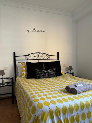 a bedroom with a large bed with yellow and white sheets at APARTAMENT SARDINA NEAR THE BEACH WITH POOL AND WIFI e in Gáldar