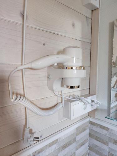 a bathroom with a white phone on the wall at Domki Zaczarowana Łąka w Borach Tucholskich in Wełpin