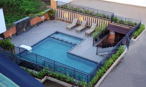 vista sul soffitto di una piscina con sedie di Hotel Indriya Wayanad a Kalpetta