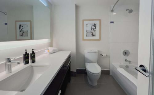 a bathroom with a sink and a toilet and a tub at Coast Bastion Hotel in Nanaimo