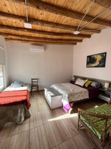 a bedroom with two beds and a wooden ceiling at Casa RoMa in Vista Flores