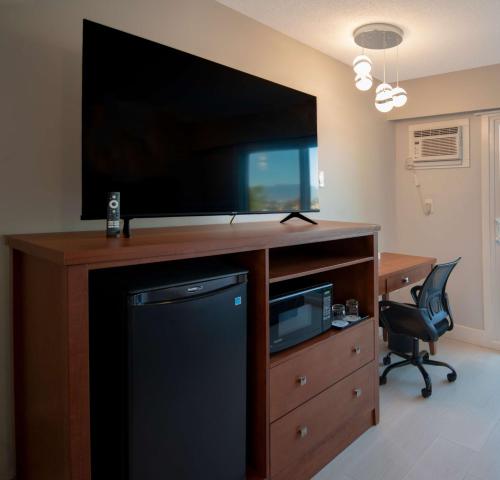 een grote flatscreen-tv bovenop een bureau bij Coast Metro Vancouver Hotel in Burnaby