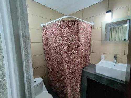 a bathroom with a red shower curtain and a sink at Love in the city in Guatemala