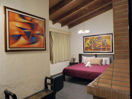 1 dormitorio con 1 cama y una pintura en la pared en Love in the city, en Guatemala