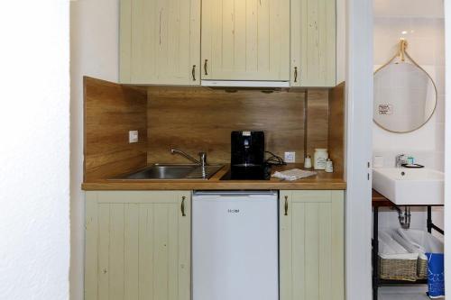 a kitchen with white cabinets and a sink and a counter at Nikiti Seafront Blue in Nikiti