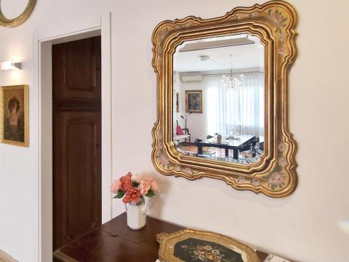 un espejo en una pared con un jarrón de flores en una mesa en Mancini 1 - Gran Madre en Turín