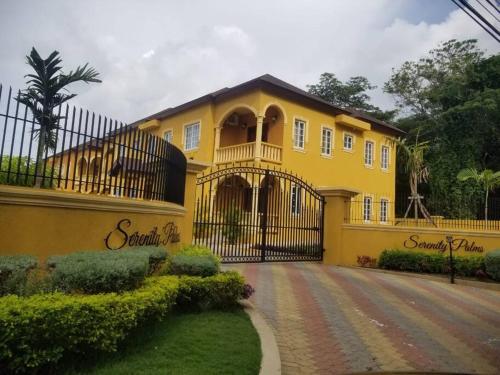 uma casa amarela com um portão em frente em Serenity Escape em Runaway Bay