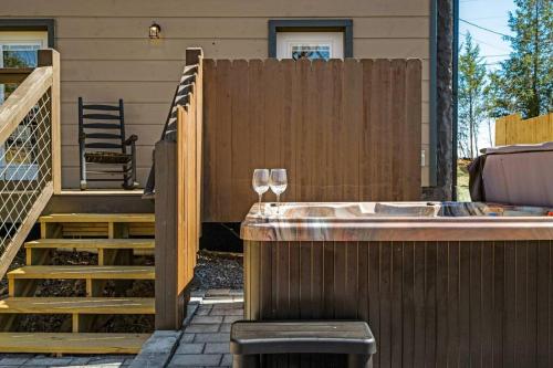 a wine glass sitting on a fence next to a hot tub at Tranquility/Mountain Cabin/Indoor Pool/Hot Tub/Games/Views in Sevierville