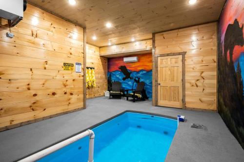 una piscina en una habitación con paredes de madera en Tranquility/Mountain Cabin/Indoor Pool/Hot Tub/Games/Views, en Sevierville