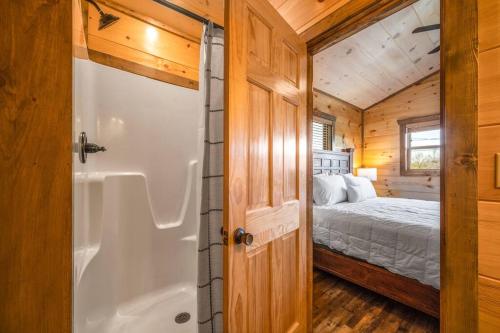 a bathroom with a shower and a bed in a cabin at Tranquility/Mountain Cabin/Indoor Pool/Hot Tub/Games/Views in Sevierville