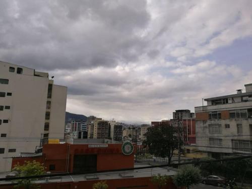 a city with tall buildings and a cloudy sky at Apartamento Edificio Tuncahuan, 12 de octubre a 50mts Swissotel in Quito