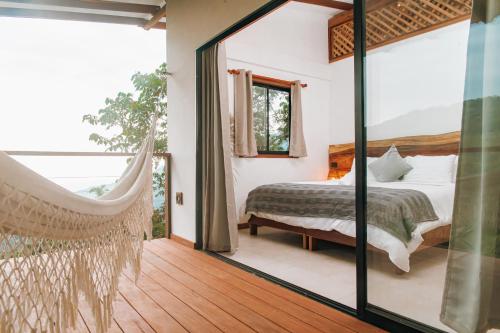 a bedroom with a bed and a hammock in a room at Masaya Casas Viejas in Minca