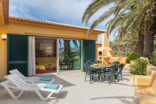 eine Terrasse mit einem Tisch und Stühlen sowie ein Esszimmer in der Unterkunft Casa do Ribeiro Salgado by An Island Apart in Porto Santo