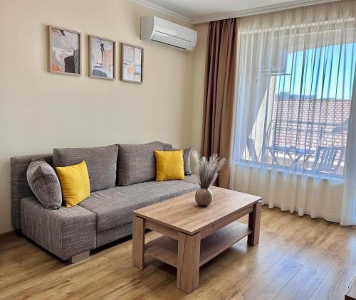 a living room with a couch and a table at Апартаменти Bella Deluxe in Ravda