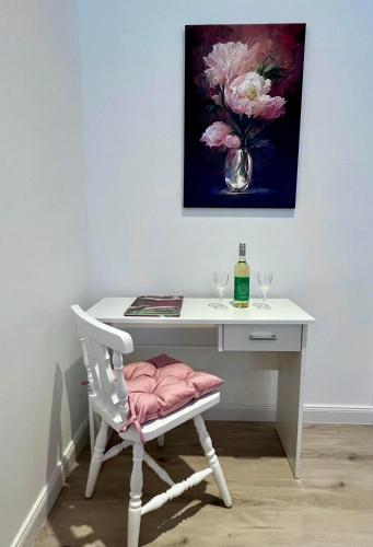 a white desk with a white chair and a vase of flowers at Wagner Villa 902 with free private parking in Budapest