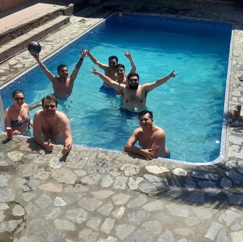 a group of men in a swimming pool at Cabañas Campestres Villa Bella in Coroico Viejo