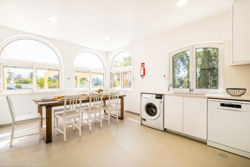 a kitchen with a dining room table and some windows at Solar dos Gandums by Atlantic Places in Pêra