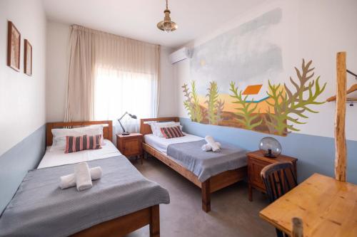 ein Schlafzimmer mit 2 Betten und einem Wandgemälde in der Unterkunft MUTE Hostel Milfontes in Vila Nova de Milfontes