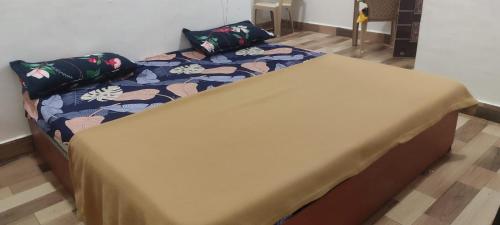 a large bed in a room with a bedspread and pillows at Sunshine Resort in Surai