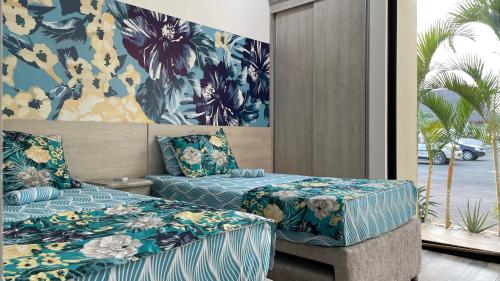 a bedroom with two beds with blue and yellow flowers at Casa en condominio in Flandes