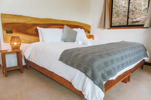 a bedroom with a large bed with a wooden headboard at Masaya Casas Viejas in Minca