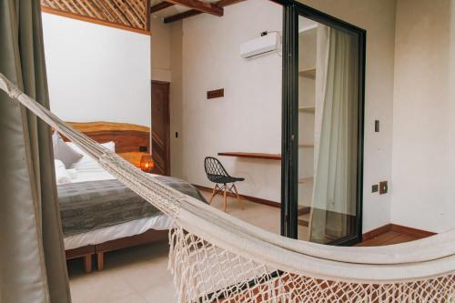 a hammock in a room with a bed and a bedroom at Masaya Casas Viejas in Minca
