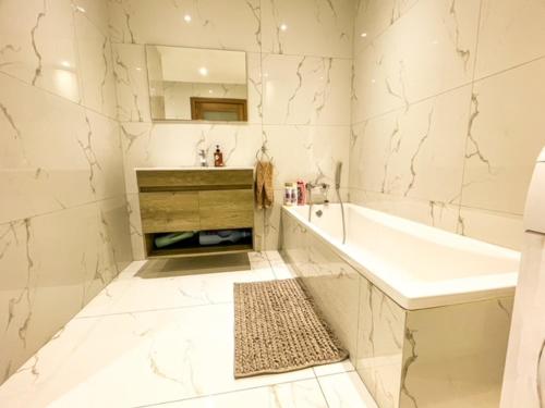uma casa de banho branca com uma banheira e um lavatório em Sliema Jacuzzi Flat em Sliema