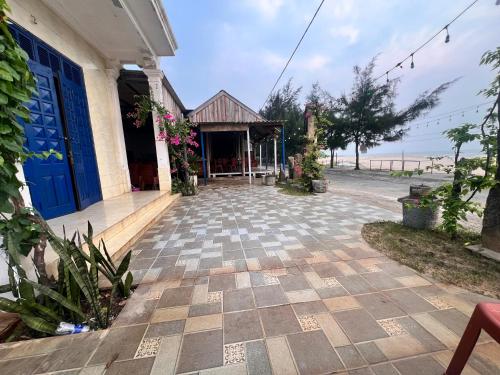 a house with a blue door and a patio at Homestay view biển in Hoằng Lễ