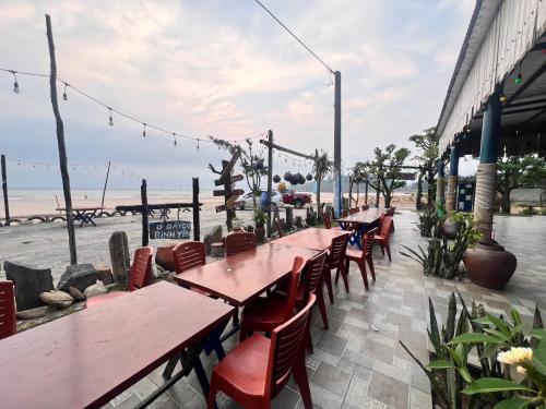 een restaurant met tafels en stoelen en het strand bij Homestay view biển in Hoằng Lễ
