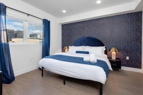 1 dormitorio con 1 cama grande y cabecero azul en Timeless Glamour: Luxury Condo in K-Town, en Los Ángeles