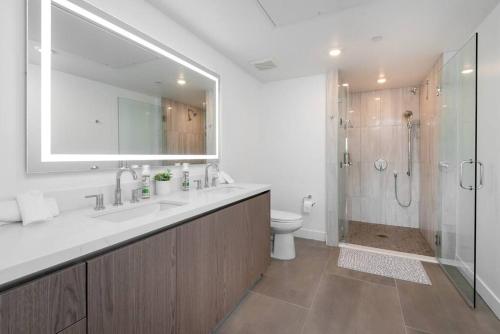 洛杉磯的住宿－Deluxe Modern 2-bedroom Condo w/ Roof Deck!，一间带水槽、卫生间和淋浴的浴室