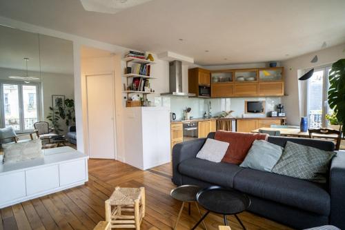 un salon avec un canapé et une cuisine dans l'établissement Nice Appartment near Buttes Chaumont, à Paris