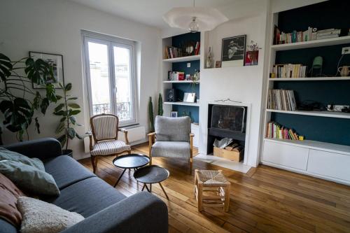 - un salon avec un canapé, des chaises et une cheminée dans l'établissement Nice Appartment near Buttes Chaumont, à Paris