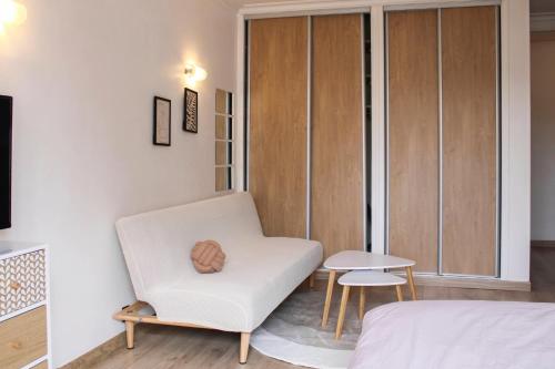 een slaapkamer met een witte stoel en een tafel bij Cosy studio with balcony in Montreuil in Montreuil