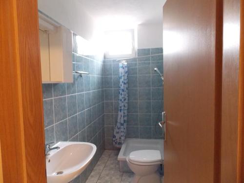 ein Badezimmer mit Toilette und Waschbecken in der Unterkunft Otok Krk Apartments in Čižići