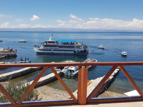a ferry boat in the water with boats at Hostal Phaxsi in Comunidad Yumani