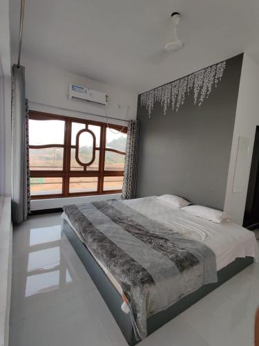 a bedroom with a bed with a large window at Sunshine Resort in Surai