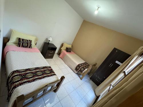 1 dormitorio en el ático con 2 camas y 1 cama pequeña en Departamentos Malargue en Malargüe